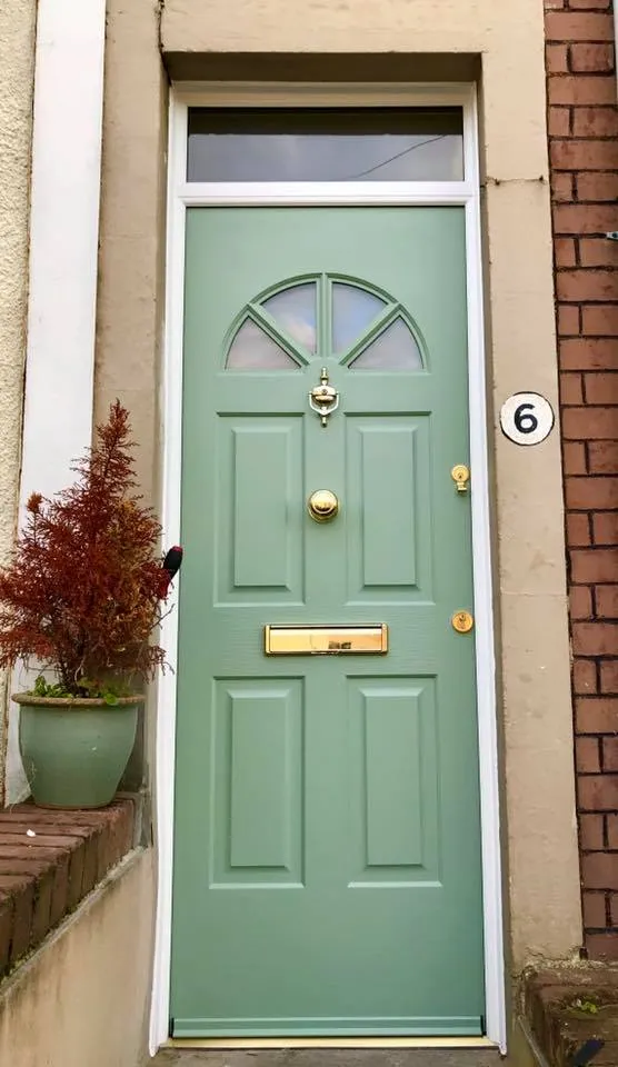 a green front door with a potted plant next to it