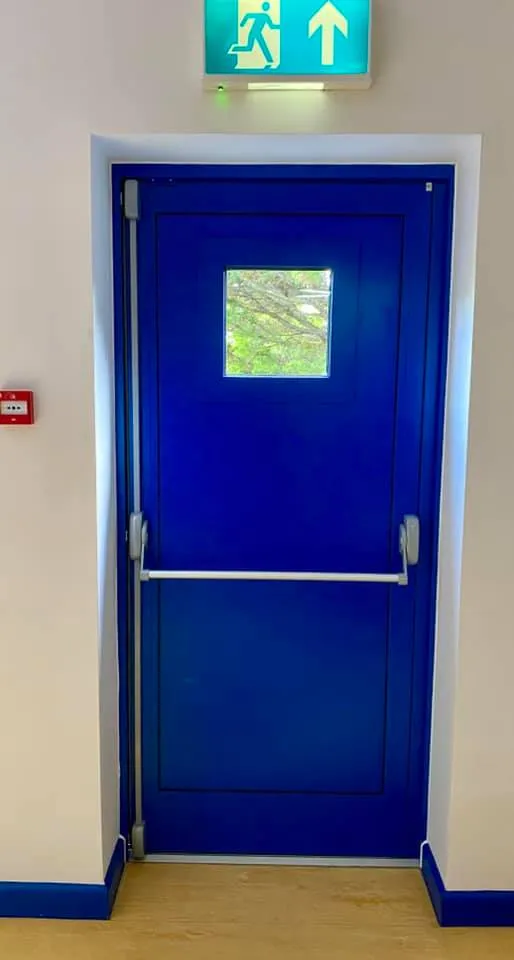 a blue door with a sign above it