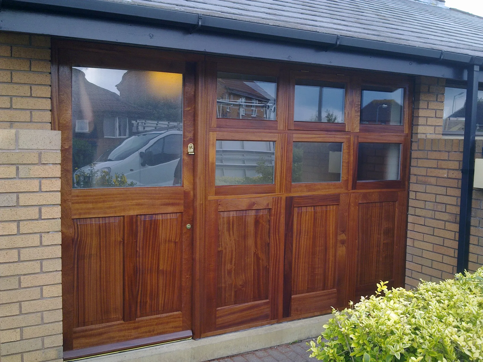 a wooden garage door with glass panels