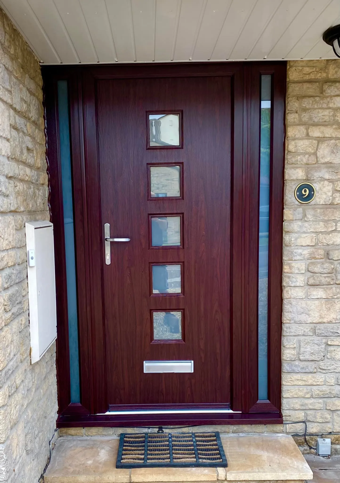 a wooden front door with glass inserts